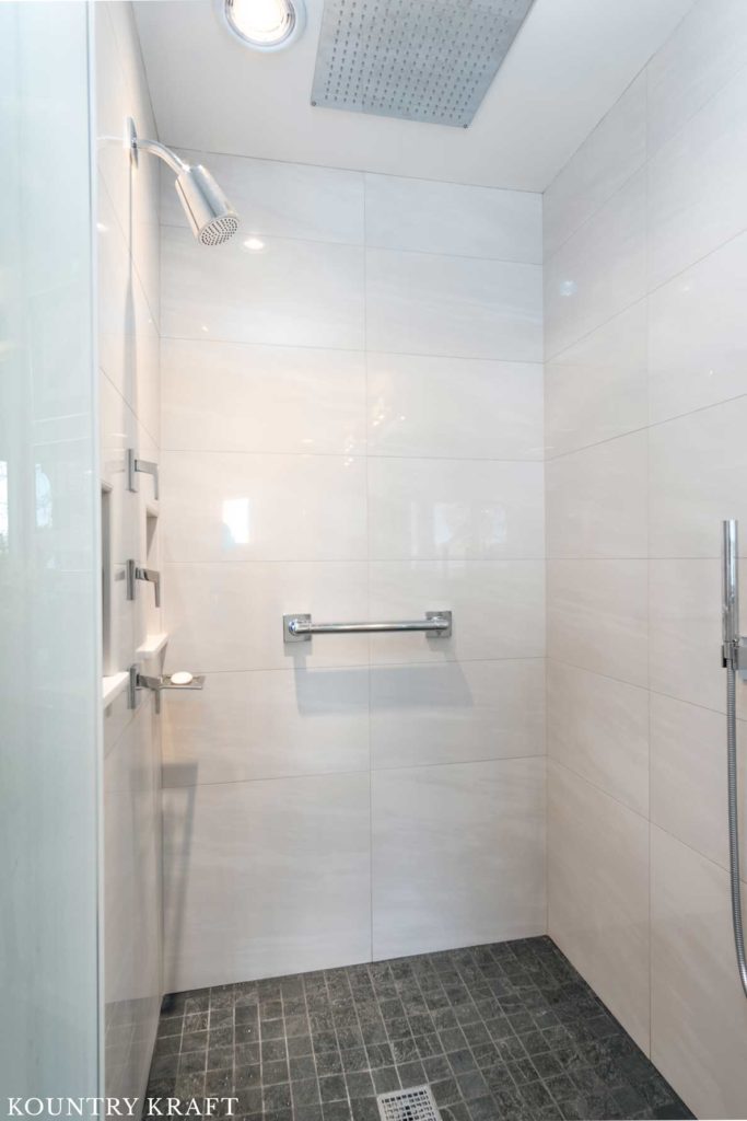 Walk-In Shower with white tile walls and silver fixtures in Winchester, Massachusetts
