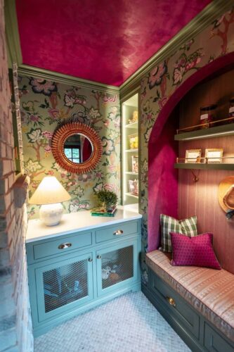 Designer Show House mudroom with green cabinetry, floral wallpaper, and cozy bench seating.