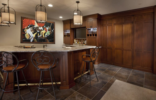 A luxury dining room bar cabinet in Ellicott City, MD crafted from rich Lyptus wood featuring stemware racks and a hidden door.
