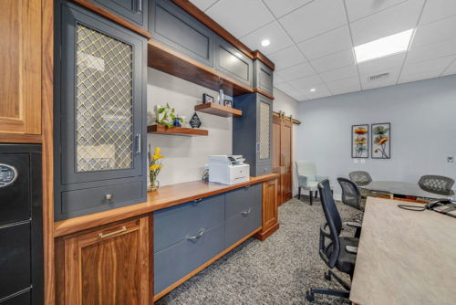 Custom office cabinets with mesh door inserts and floating shelves