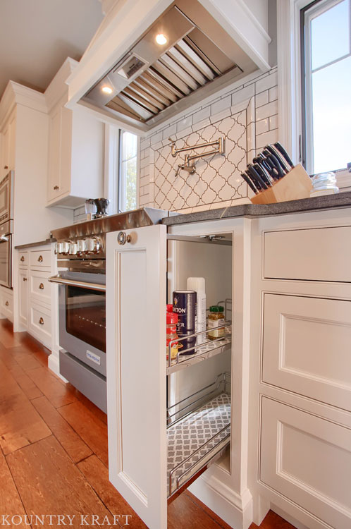 Extra White Kitchen Cabinet contains Hidden Spice Rack cleverly placed next to stainless steel range