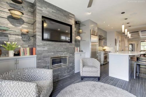 Transitional Family Room Featuring a Custom Entertainment Area Including Glass Shelving and Fireplace