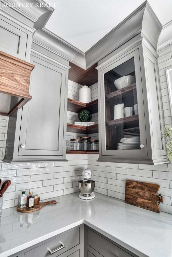 Dovetail Gray Cabinets with Glass Doors and Walnut Shelves against White Subway Tile Backsplash