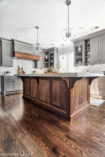 Walnut Wood Kitchen Island Cabinets feature arched support brackets for the kitchen countertop 