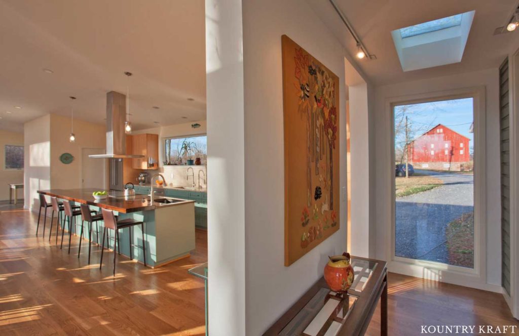 The Entry Way Features Two Openings Leading to the Kitchen with Teal Kitchen Cabinets