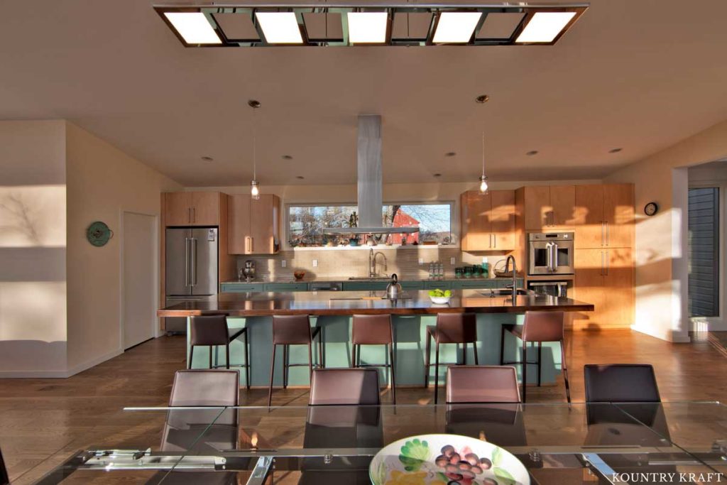 This Contemporary Kitchen Island Features Teal Kitchen Cabinets and an Abundant Amount of Seating 