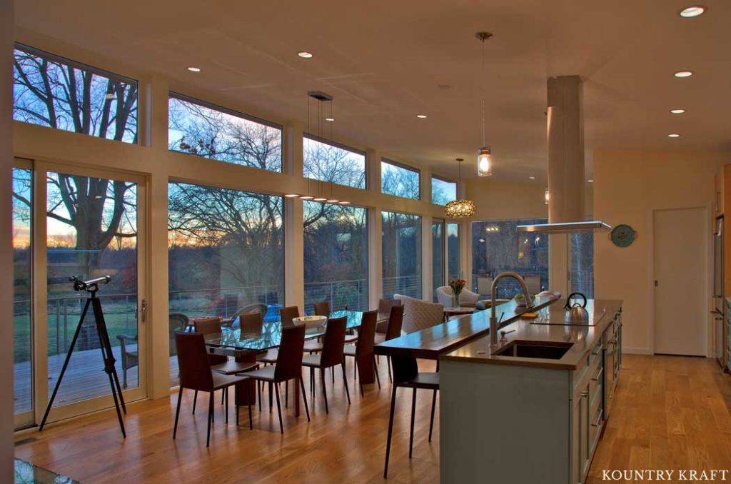 This Contempoaray Kitchen Features Teal Kitchen Cabinets and Large Glass Windows to Allow Maximum Sunlight