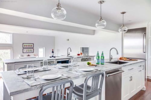 Kitchen island with sink, chairs, and place settings Madison, NJ