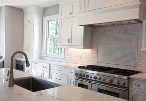 White cabinets, range, oven, and island with sink Madison, NJ