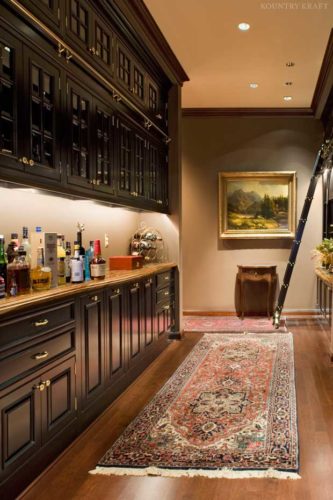 custom home bar with custom cabinets to display the clients exquisite wine and spirits collection 