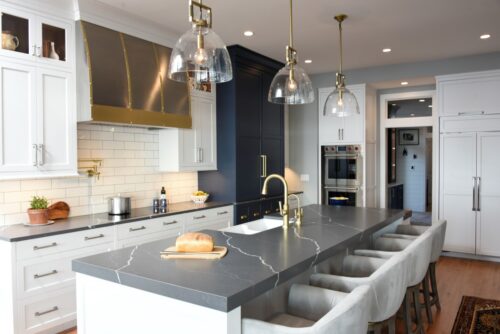 Discover a custom white and blue kitchen and butler’s pantry in Edgewater, MD, designed by Tina Colebrook Kitchens with Kountry Kraft’s hard maple cabinets. Functional design meets modern style. Island with seating for four.