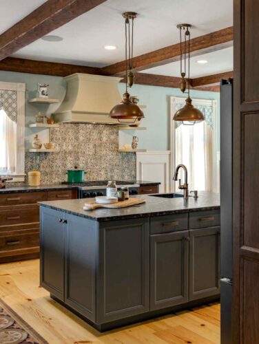 Full view of kitchen remodel in White Mountains NH featuring custom Kountry Kraft cabinetry, exposed beams, and central island.