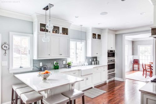 This Kitchen Color Scheme included White Cabinetry with a Light Grey Subway tile and a Medium Hardwood Floor