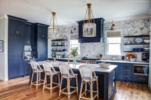 This Kitchen Color Scheme included Navy Blue Cabinetry with Medium Hardwood Floors and a Multi-Gray Backsplash