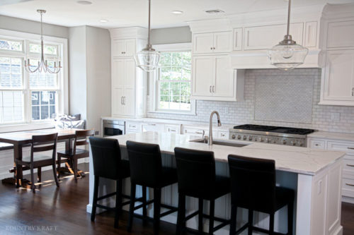 A custom range hood design finished in a white paint creates the kitchen focal point