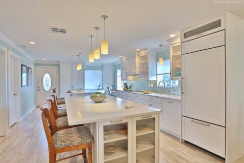 Cabinet refrigerator, island with glass panel doors, and hanging lights Venice, FL