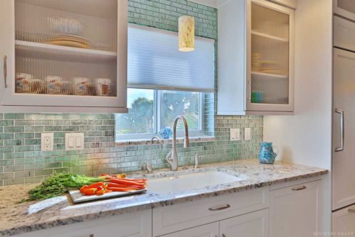 Counter, sink, vegetables, and cabinets with glass doors Venice, FL