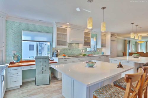Kitchen featuring two islands, counter, white cabinets, and a desk Venice, FL