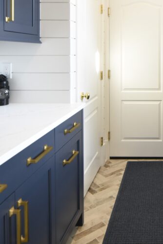 Laundry room remodel in Edgewater MD with custom Hale Navy cabinetry, brass accents, and shiplap walls. Focus is on Hale Navy cabinetry with Matte brass hardware.