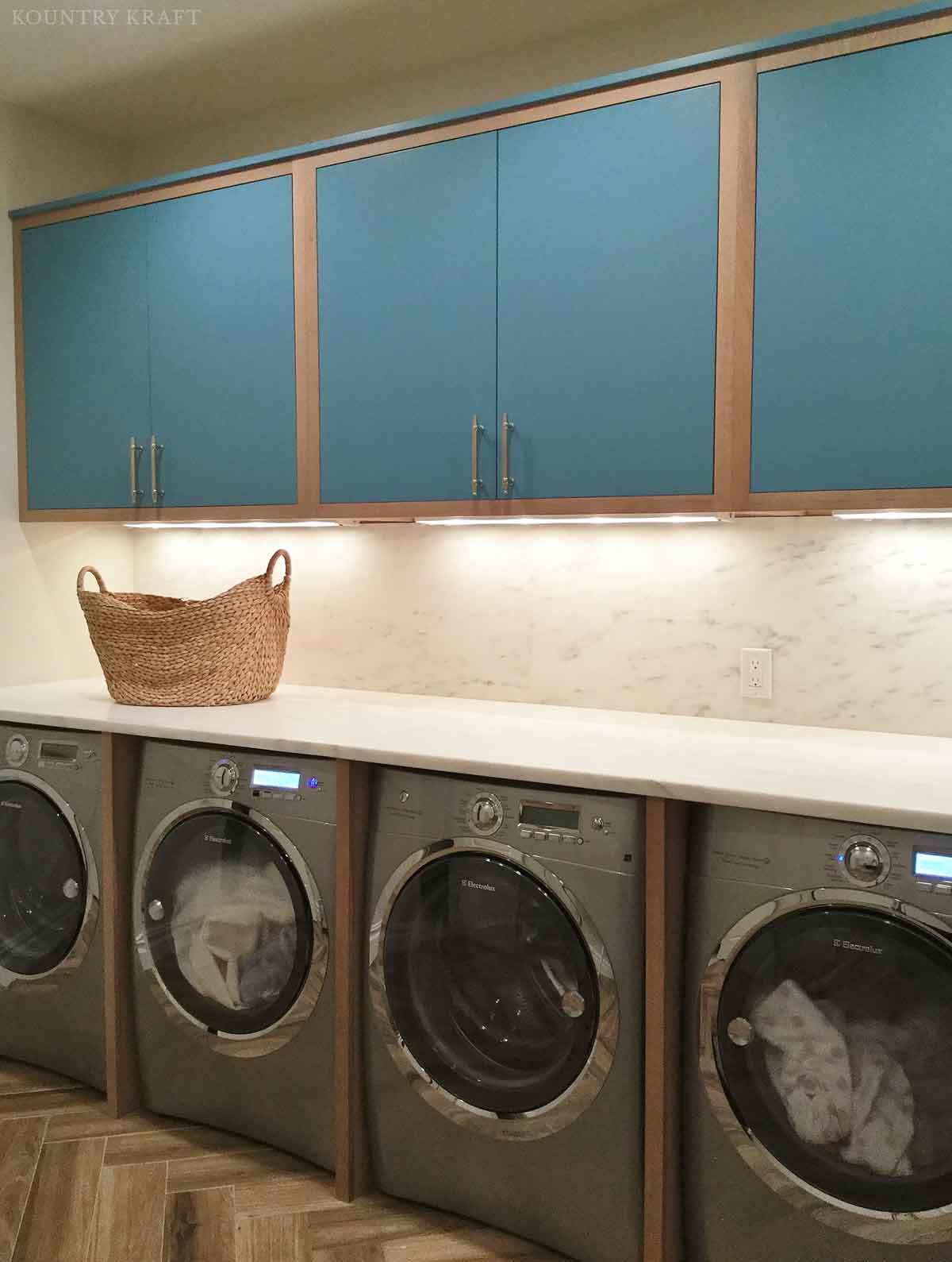 Laundry room with manitou blue cabinets and counter over four machines Greenwich, CT