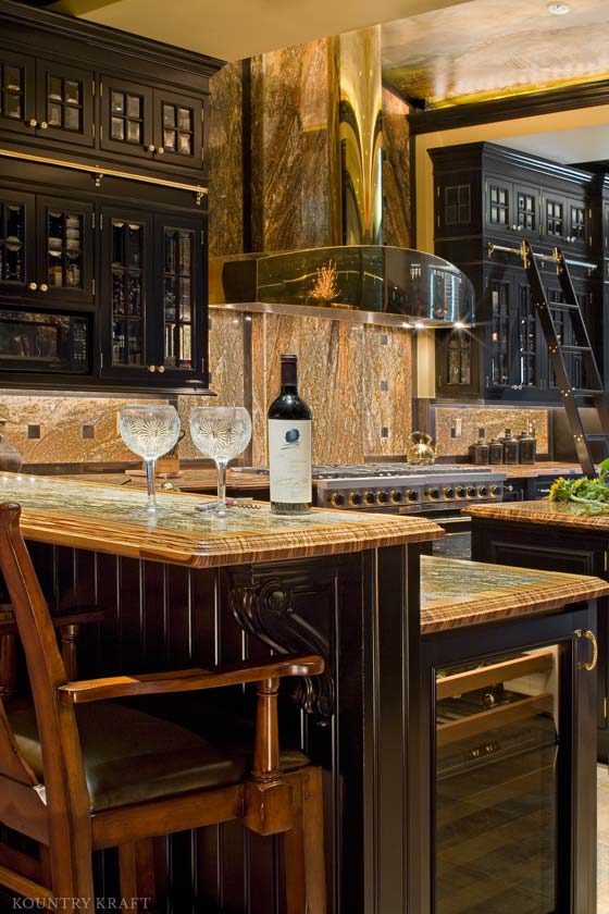 Shining kitchen with black painted maple cabinets, island, range, and gold range hood Baltimore, MD