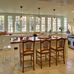 Zoom out of painted white cabinets, island with seating, range, and sink Summit, NJ