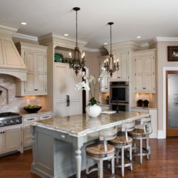 Light painted cabinets, island, stone arch, range, and range hood Mechanicsburg, PA