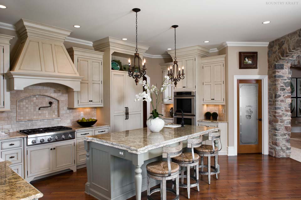 Light painted cabinets, island, stone arch, range, and range hood Mechanicsburg, PA