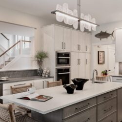 Custom kitchen remodel in Exeter NH featuring Rift Cut White Oak cabinets, island with seating for three, and Miele wall ovens.