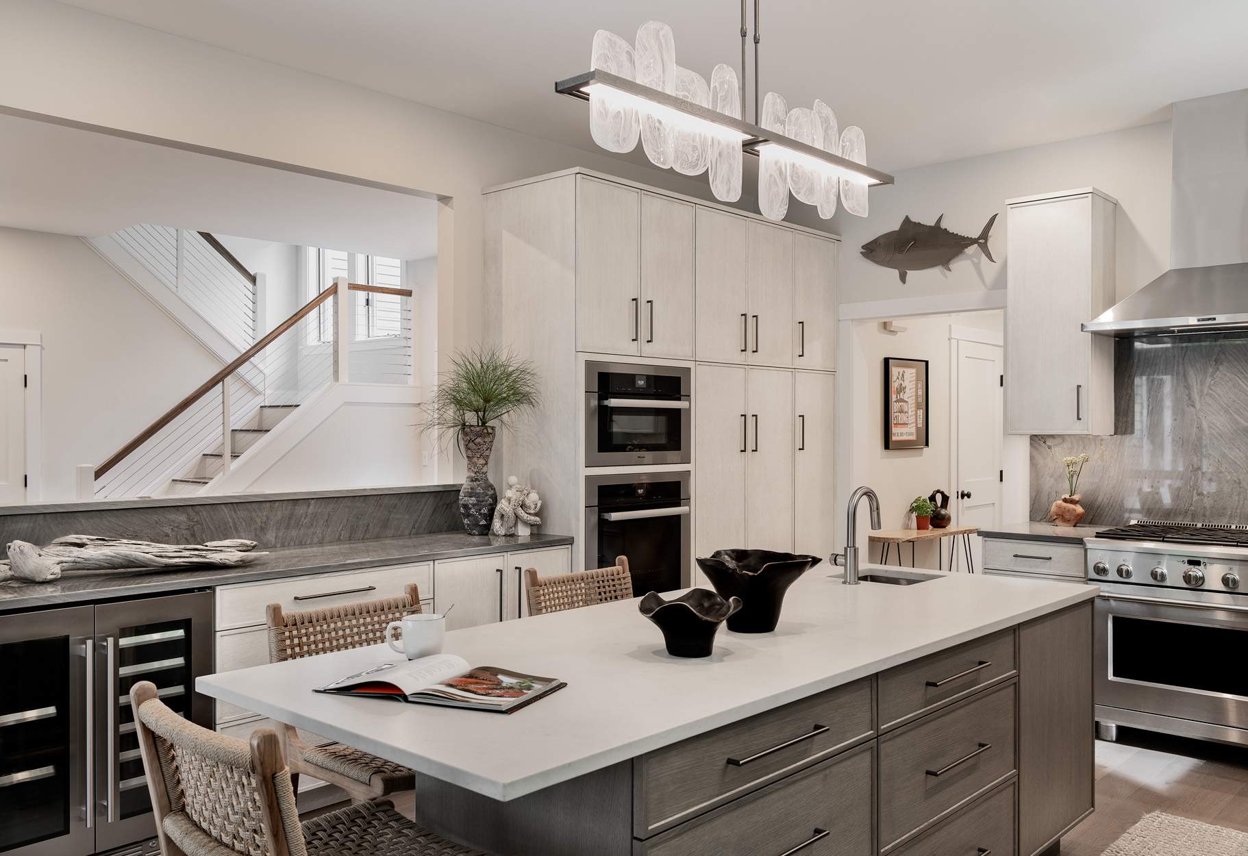 Custom kitchen remodel in Exeter NH featuring Rift Cut White Oak cabinets, island with seating for three, and Miele wall ovens.