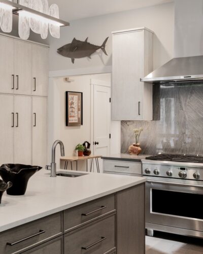 Exeter NH kitchen remodel with Rift Cut White Oak cabinets, professional gas range, stainless hood, and full-height stone backsplash.