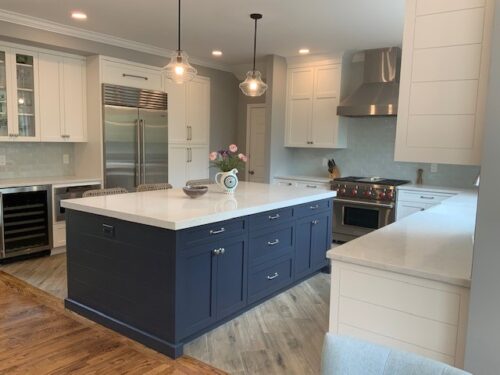 This is a picture of a white and blue kitchen with an open island in Henderson Nevada including custom cabinets by Kountry Kraft Cabinetry. 