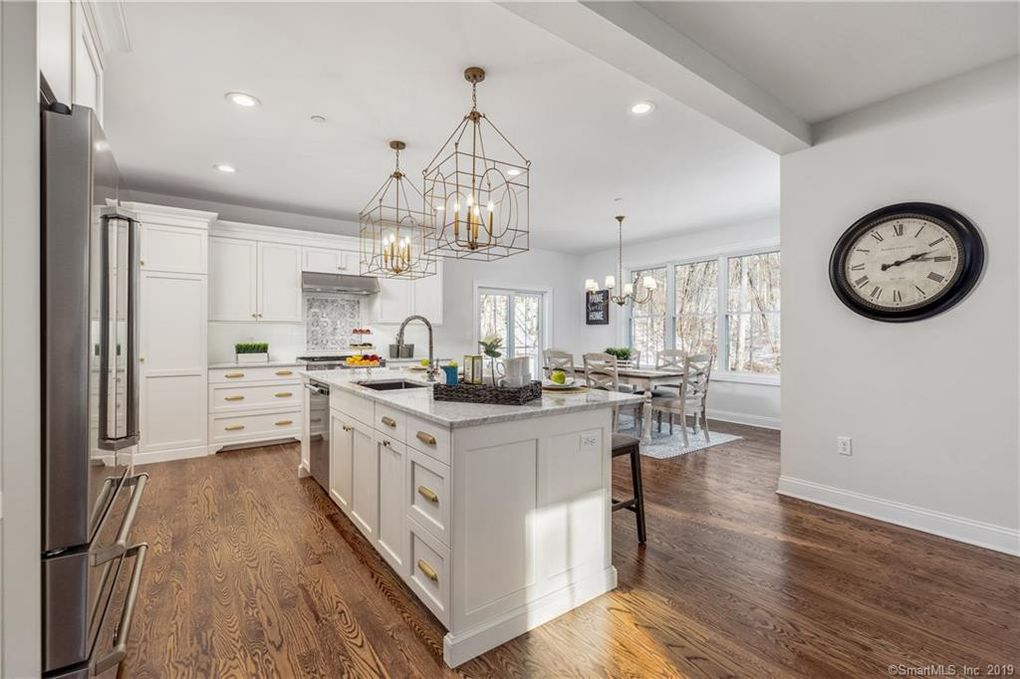 White Kitchen Cabinets with Gold Hardware and Wood Flooring