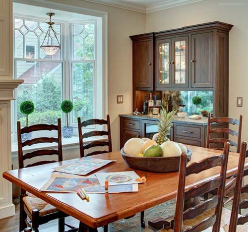 Custom dining room storage cabinets in Short Hills, NJ featuring warm walnut wood with an English Walnut stain and luxury beaded inset doors.