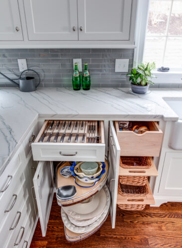 white kitchen cabinetry displaying corner cabinet pull outs, cutlery drawer and pull out drawers.