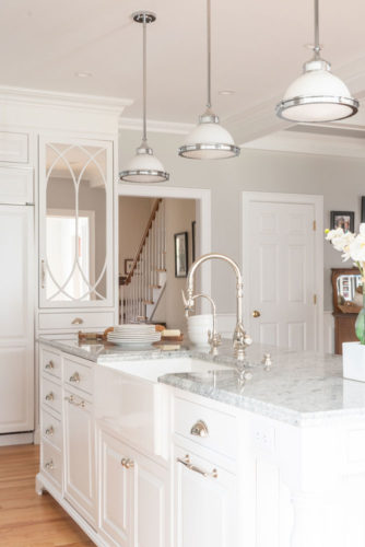 Super White Kitchen Island with an Apron Sink and Stainless Fixtures