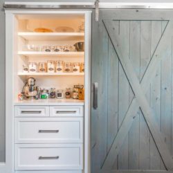 Built-In Pantry with White cabinets, open shelves and a sliding barn door in West Newbury, Massachusetts