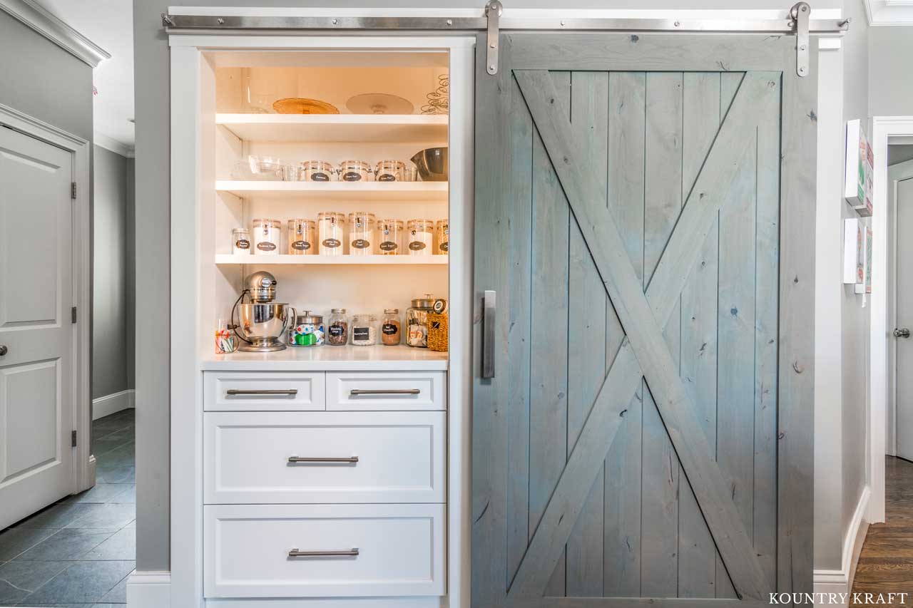 Built-In Pantry with White cabinets, open shelves and a sliding barn door in West Newbury, Massachusetts