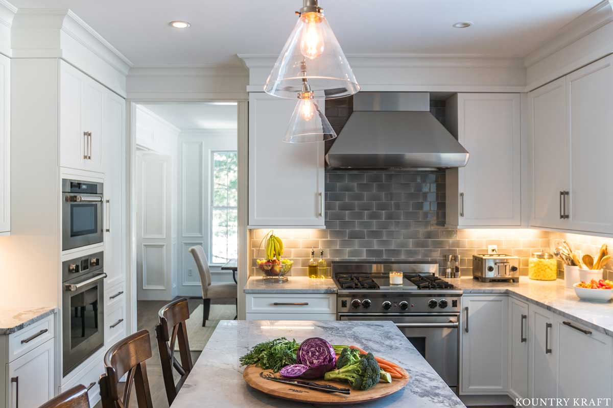 Transitional Farmhouse Kitchen with White Cabinets, Gray Subway Tile and Stainless Steel Appliances 