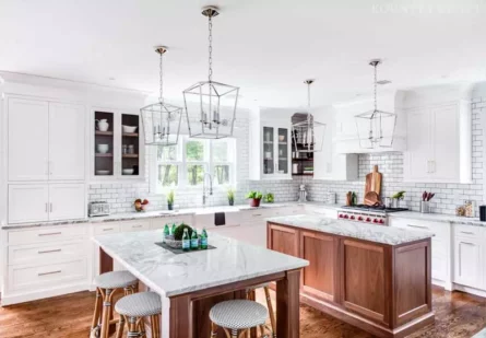 White painted cabinets for the kitchen perimeter complimented by two kitchen islands with natural walnut finish