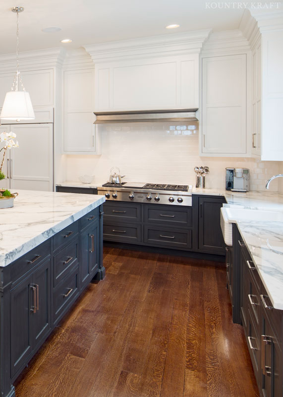 Transitional two tone kitchen cabinets with a custom stainless metal fusion range hood mantle