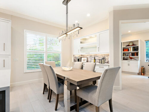 White custom dining room cabinets in Venice, FL featuring full overlay doors and seamless integration into an open-concept kitchen and dining layout.