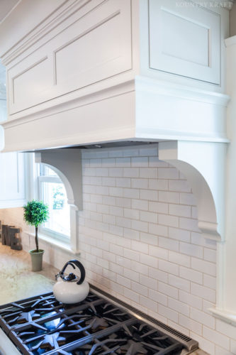 Range with kettle and white range hood