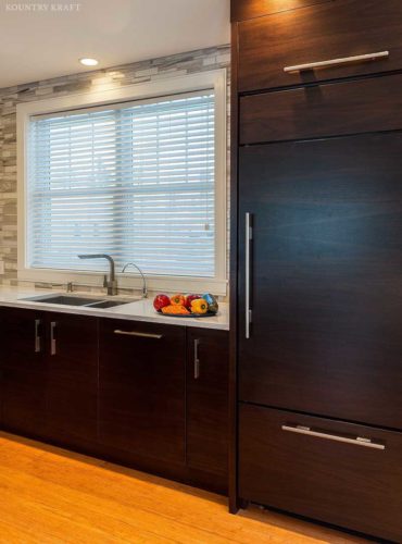 Kitchen with undermount sink under a large window and walnut cabinetry Swampscott, MA