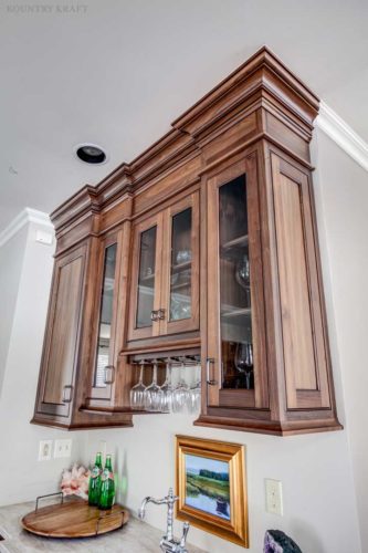 Walnut wet bar with glass panel cabinet doors and stemware racks Madison, NJ