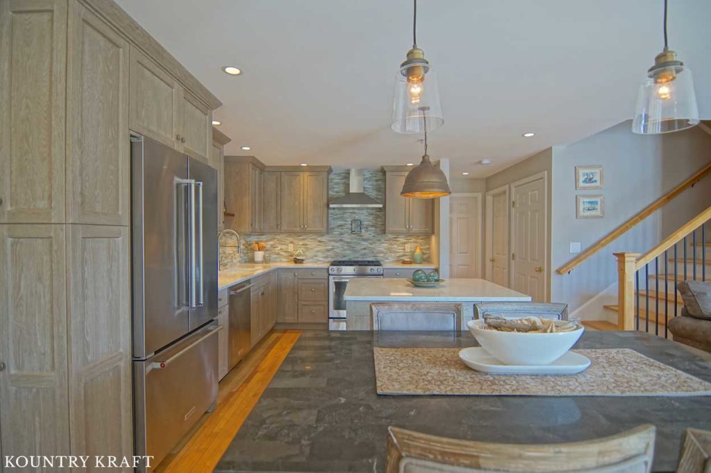 Weathered Grain Cabinets Coincide with the Stainless Steel Appliances Located around this Transitional Kitchen 