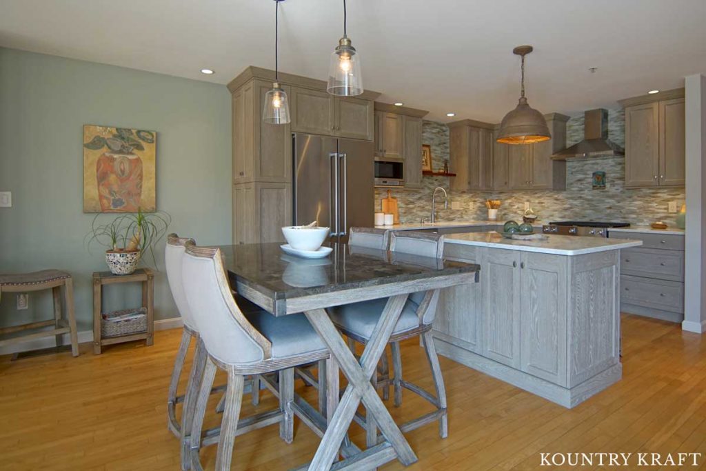 This Transitional Kitchen Features a Dining Room and Kitchen Island with Weathered Grain Cabinets