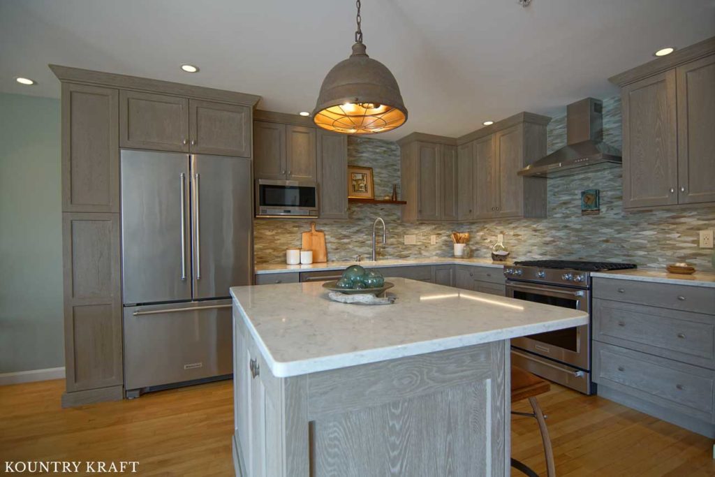 All the Weathered Grain Cabinets Create Organization and Storage Solutions in this Transitional Kitchen 