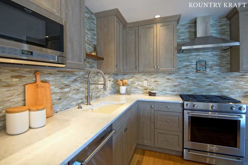 Stainless Steel Appliances Compliment the Weathered Grain Cabinets Featured in this L Shaped Kitchen 