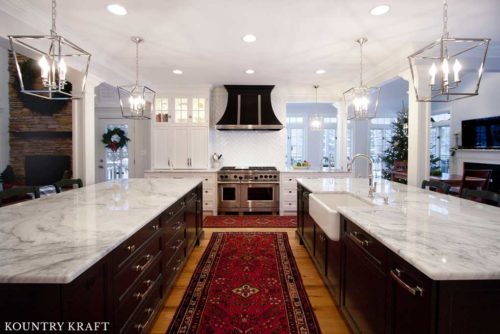 This Kitchen Features White and Black Kitchen Cabinets and A Stainless Steel Oven Range
